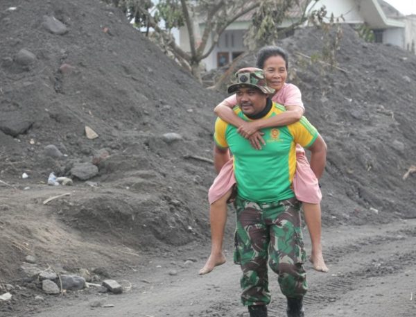 TNI gendong nenek yang kesulitan berjalan